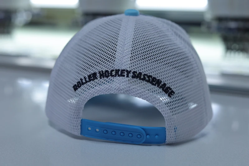 Rear of a white mesh trucker cap with blue plastic snapback closure and dark rear embroidery