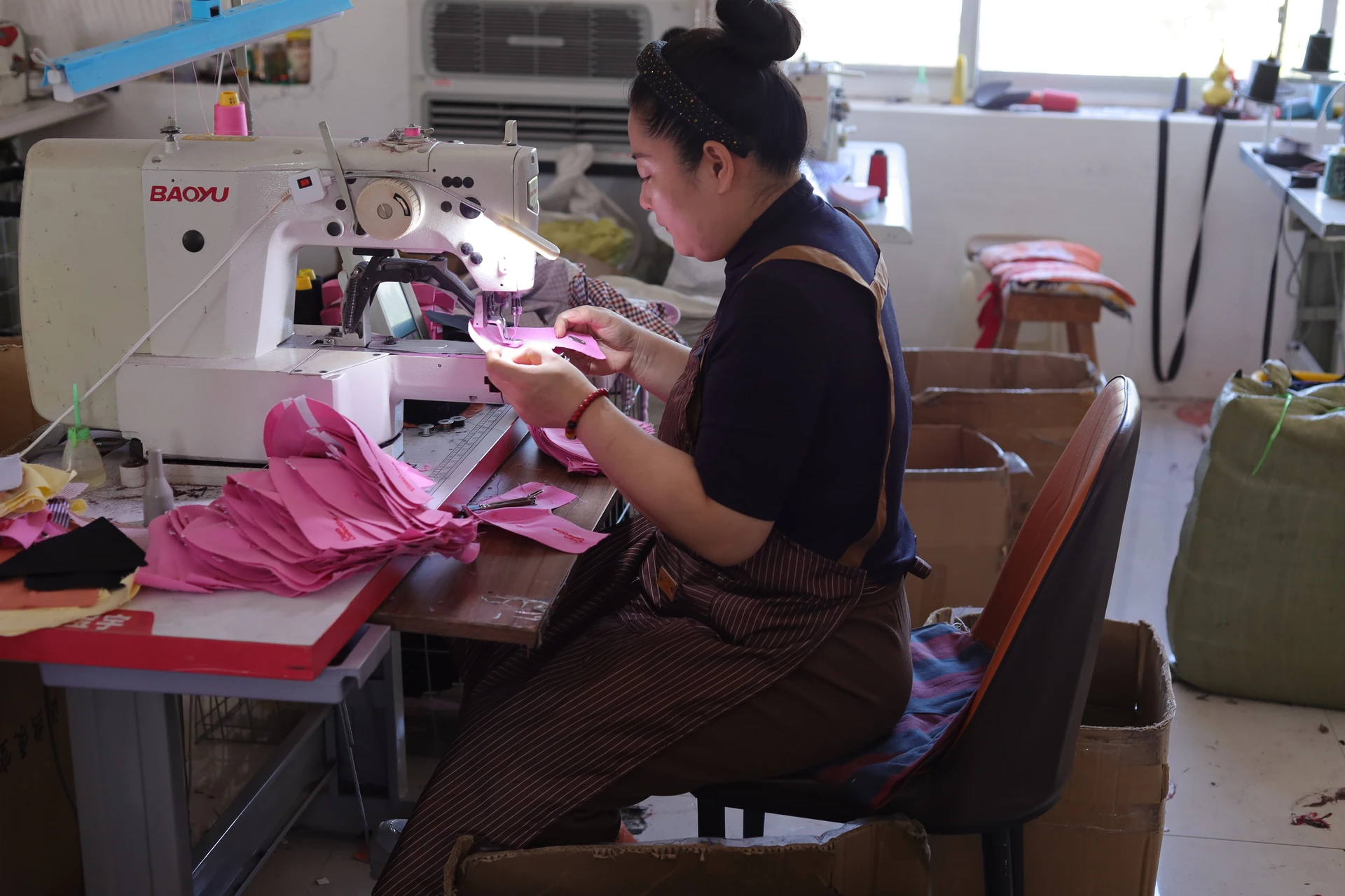 Cap fabric panels at an industrial sewing workstation