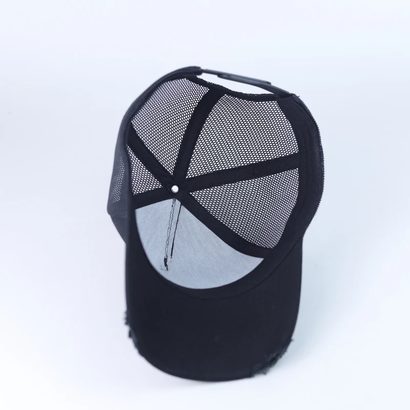 Inside view of a black mesh trucker cap with internal panel seams and crown junction